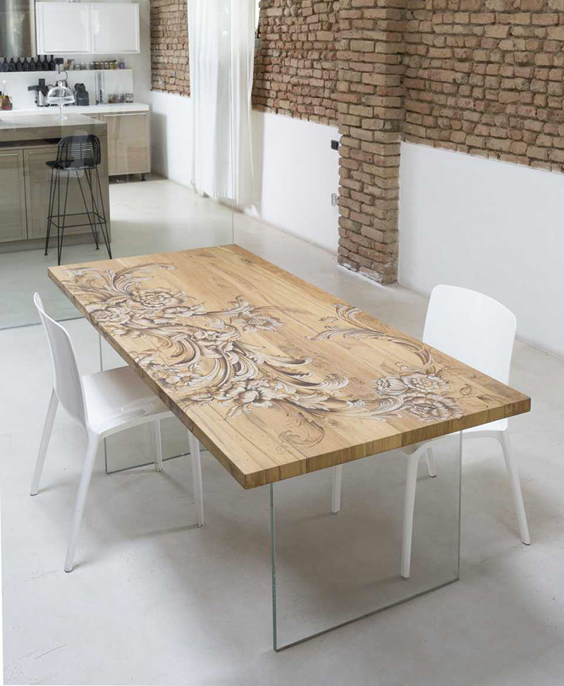 Tavolo in legno e cristallo che unisce artigianalità e modernità.