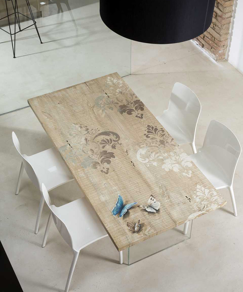 Tavolo in legno dipinto a mano e basamento in cristallo trasparente.