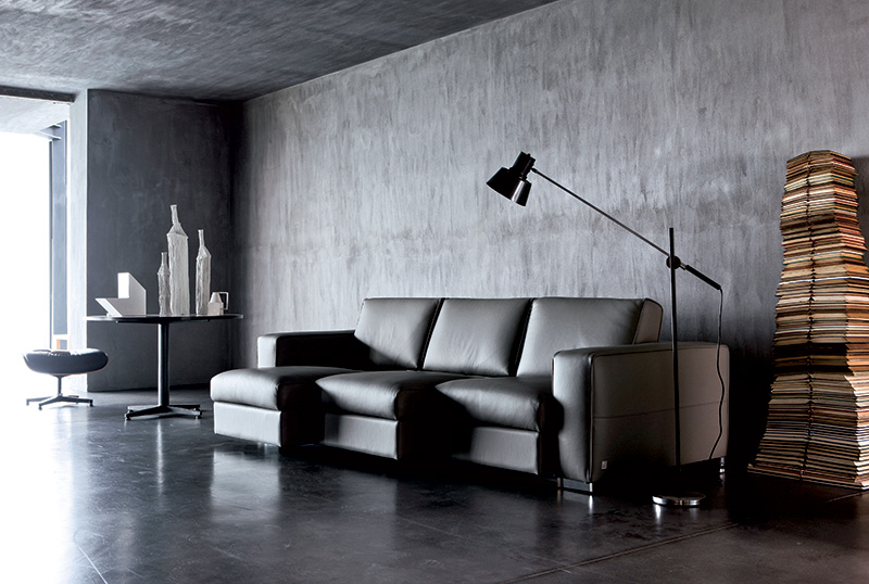 Stile neo dark in soggiorno: pareti nere, divano in pelle nera di Doimo Salotti.