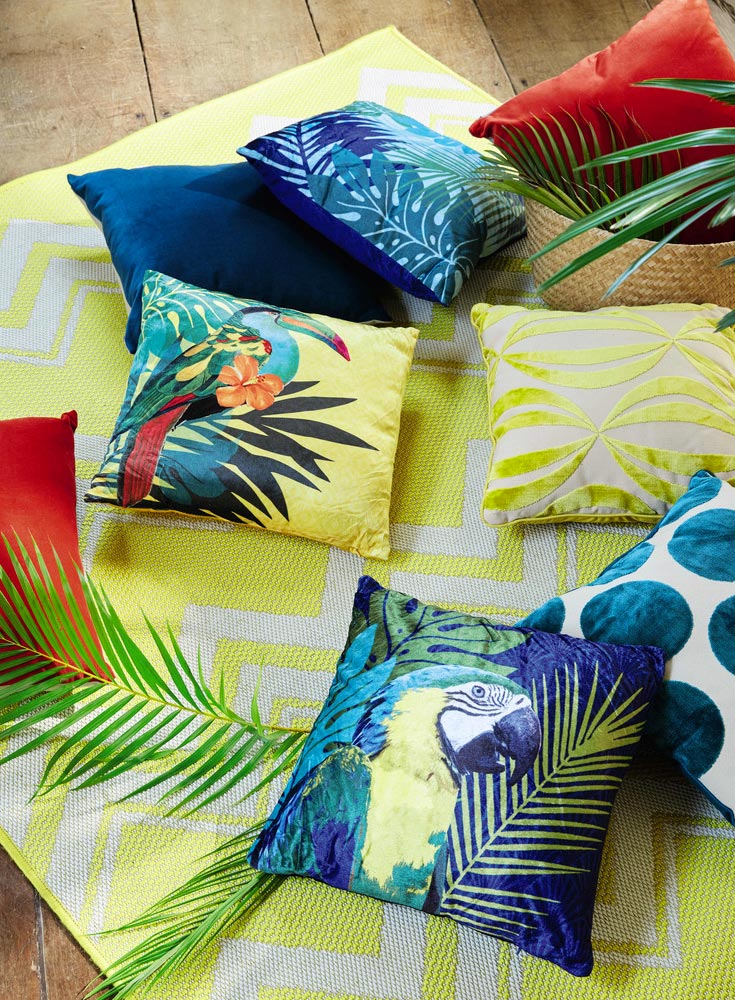 Cuscini coloratissimi con stampe di uccelli tropicali.